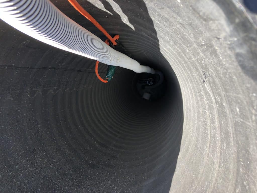 Peaking down into our drainage pipe, this nearly 20' drop leads to our water excavation system. Our sump pump is designed to remain in this chamber, even after our pool is built. It will operate with a float assembly that activates and removes water to a storm drain if the water level gets too high. It's another step that we take to ensure our customers receive a pool that is designed to last. We take the extra step to build our pools the right way!